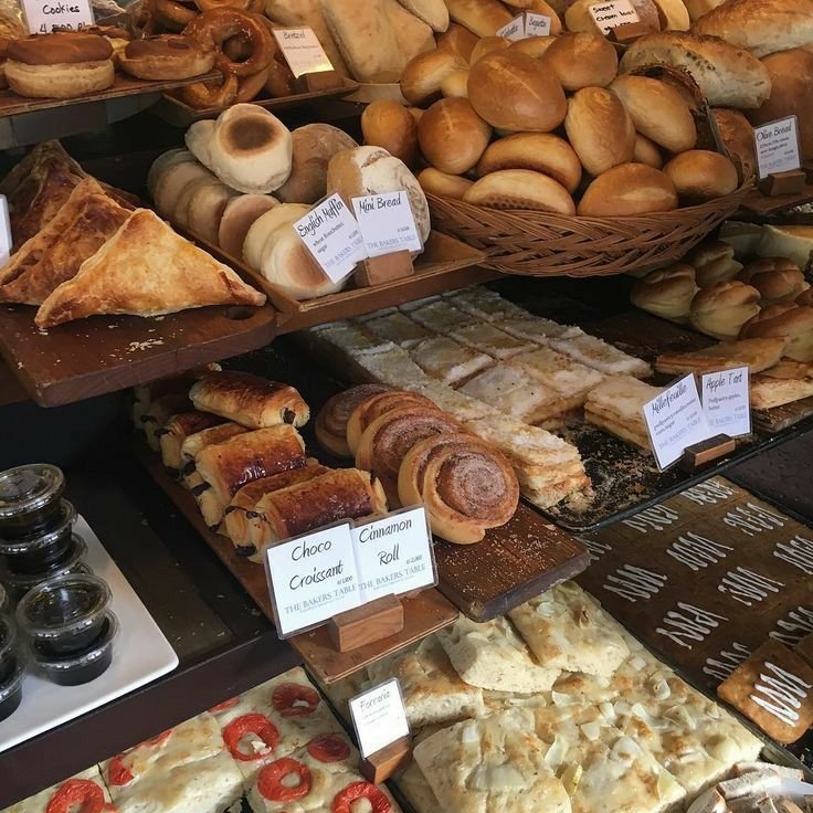 different types of breads behind the glass shelf